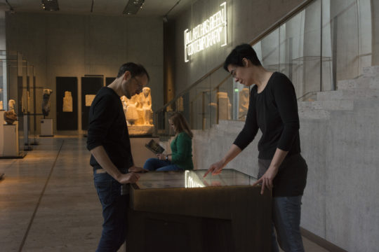 Menschen an einer Medienstation im Museum