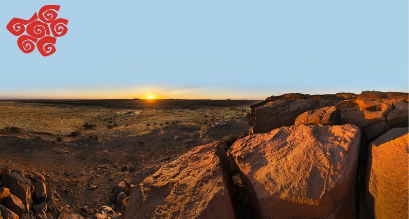 Blick vom Gebel Naga hinunter auf die Ebene. Am Horizont geht die Sonne unter.