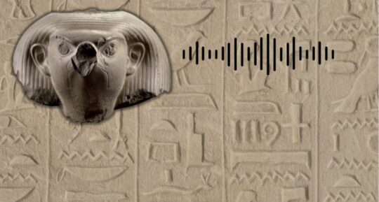 Auf einem Hieroglyphenhintergrund der Kopf einer Falkenstatue mit Ohren aus weißem Stein, darüber ein Audiosymbol.