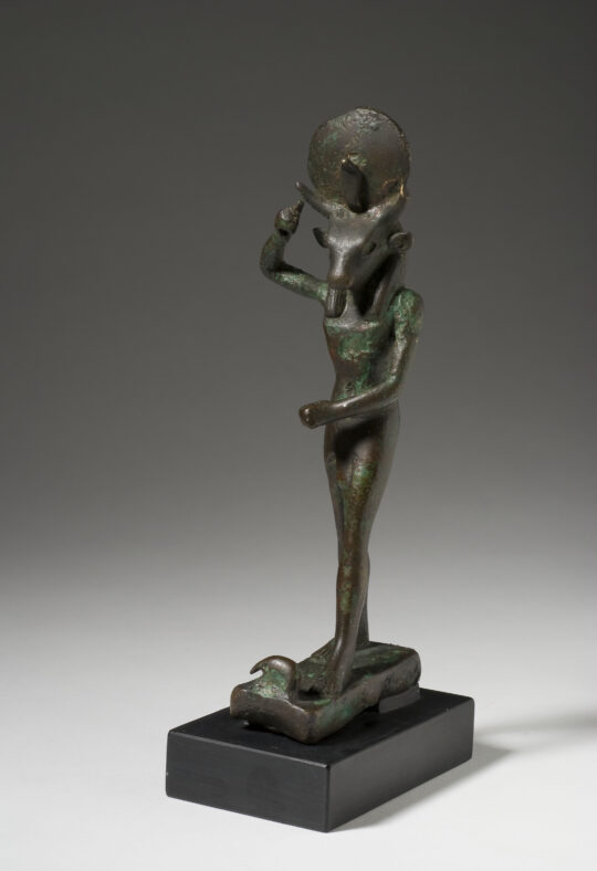 Stehender stierköpfiger Gott aus Bronze, die Arme erhoben, als ob er einen Speer trägt.