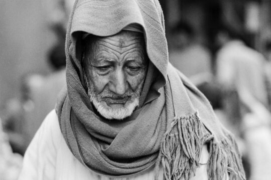 Ein alter mann mit weißem Bart und einem Tuch um den Kopf