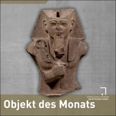 Ankündigungsbild "Objekt des Monats": auf einem Betonhintergrund das Oberteil einer Statue von Ramses II. aus hellem Sandstein
