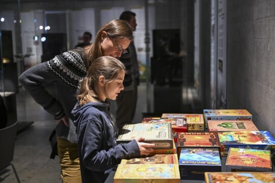 Zwei Personen stehen vor einem Tisch mit Brettspielen