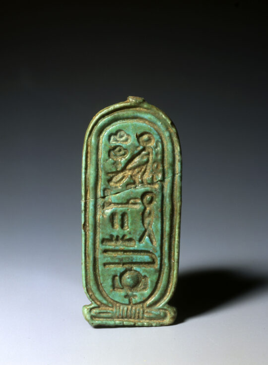 Eine tiefgrüne Kartusche aus Fayence mit Hieroglyphen beschriftet