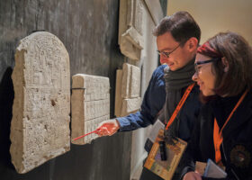 Zwei Menschen schauen auf eine altägyptische Stele