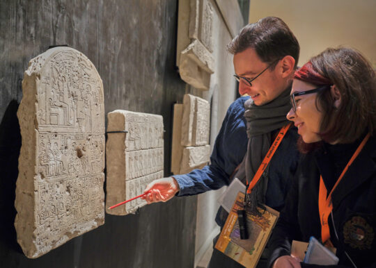 Zwei Personen schauen auf eine altägyptische Stele