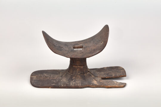 Eine Kopfstütze aus dunklem Holz kit Hieroglypheninschriften