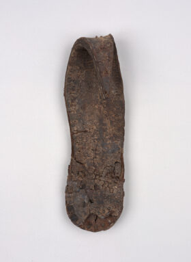 Eine dunkelbraune Schuhsohle mit gebogener Spitze